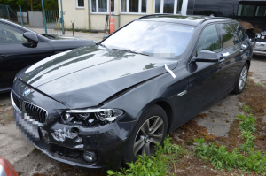 Na zdjęciu widoczny jest pojazd marki bmw koloru czarnego, który posiada rozbity przedni lewy reflektor oraz zderzak.