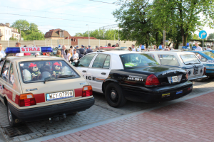 Na zdjęciu widoczny jest pojazd m-ki ford z oznaczeniami amerykańskiej policji oraz zabytkowa straż pożarna