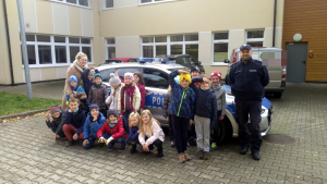 Na zdjęciu policjanci z Komendy Powiatowej Policji w Pruszkowie wspólnie z przedstawicielką Warszawskiej Kolei Dojazdowej przeprowadzają zajęcia o bezpieczeństwie przy przejazdach kolejowych i stacjach w klasach 0-3 w Szkole Podstawowej w Otrębusach.