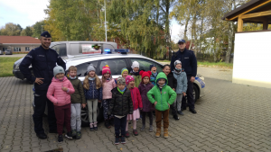 Na zdjęciu policjanci z Komendy Powiatowej Policji w Pruszkowie wspólnie z przedstawicielką Warszawskiej Kolei Dojazdowej przeprowadzają zajęcia o bezpieczeństwie przy przejazdach kolejowych i stacjach w klasach 0-3 w Szkole Podstawowej w Otrębusach.