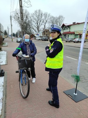 Na zdjęciu widoczna jest policjantko, która rozmawia z rowerzystką.