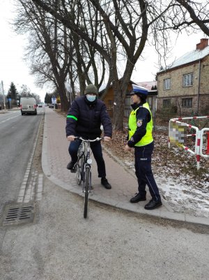 Na zdjęciu widzimy policjantkę i rowerzystę, który na ramieniu ma odblask podarowany przez funkcjonariuszkę.