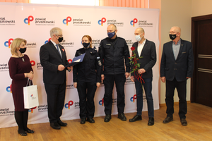 Na zdjęciu widoczni są przedstawiciele Starostwa Pruszkowskiego oraz wyróżniona policjantka wraz z Komendantem Powiatowym Policji w Pruszkowie.