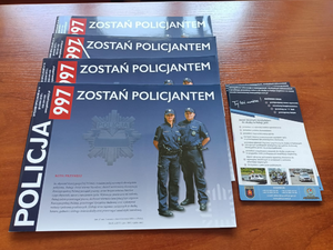 Na zdjęciu widoczne są informatory i ulotki informujące o zasadach przyjęcia do pracy w policji.