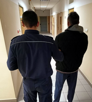 Policjant z zatrzymanym poszukiwanym- sprawcą uszkodzenia mienia