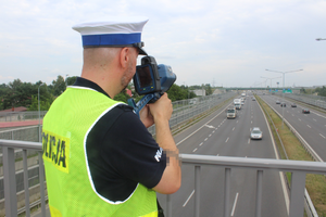 policjant dokonujący pomiaru odległości pomiędzy pojazdami