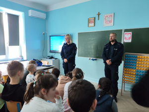 umundurowana policjantka i policjant oraz uczniowie podczas spotkania profilaktycznego.