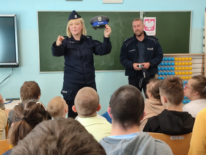 umundurowana policjantka i policjant oraz uczniowie podczas spotkania profilaktycznego.