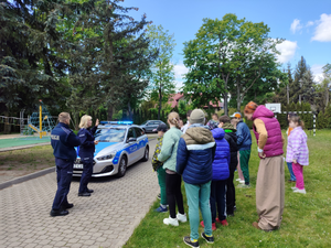 umundurowana policjantka i policjant oraz uczniowie podczas spotkania profilaktycznego.