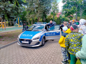 umundurowana policjantka i policjant oraz uczniowie podczas spotkania profilaktycznego.