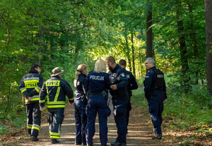 policjanci oraz strażacy pożarni podczas działań w kompleksie leśnym