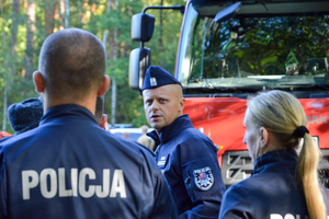 policjanci oraz strażacy pożarni podczas działań w kompleksie leśnym
