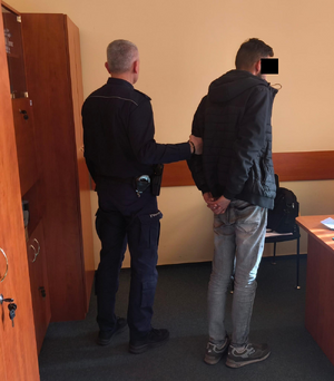 policjant z zatrzymanym mężczyzną