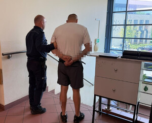 policjant z zatrzymanym mężczyzną