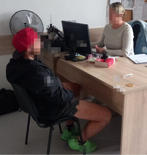 policjantka przesłuchuje zatrzymanego mężczyznę